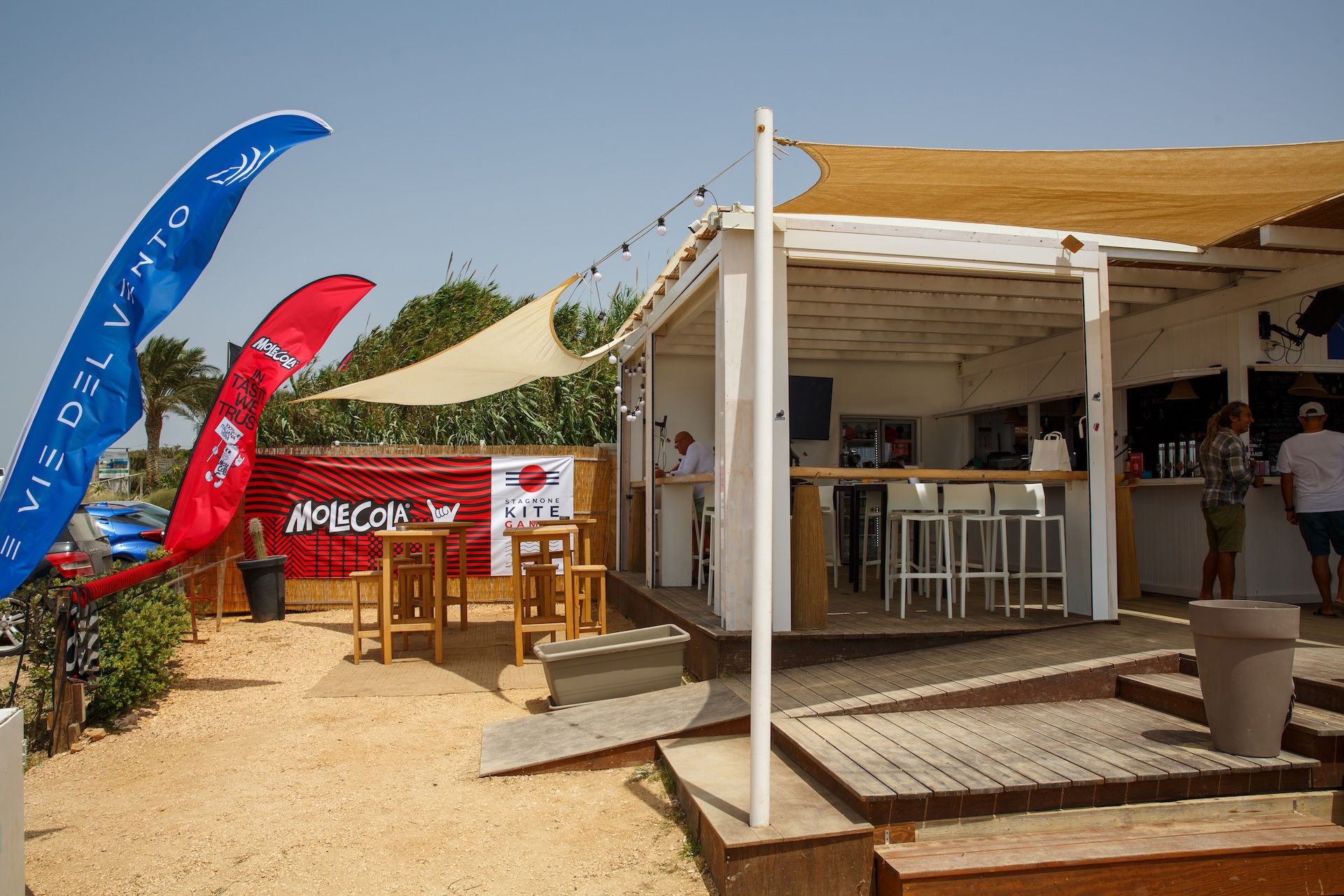 Il beach bar Le Vie del Vento con le bandiere degli sponsor 2026