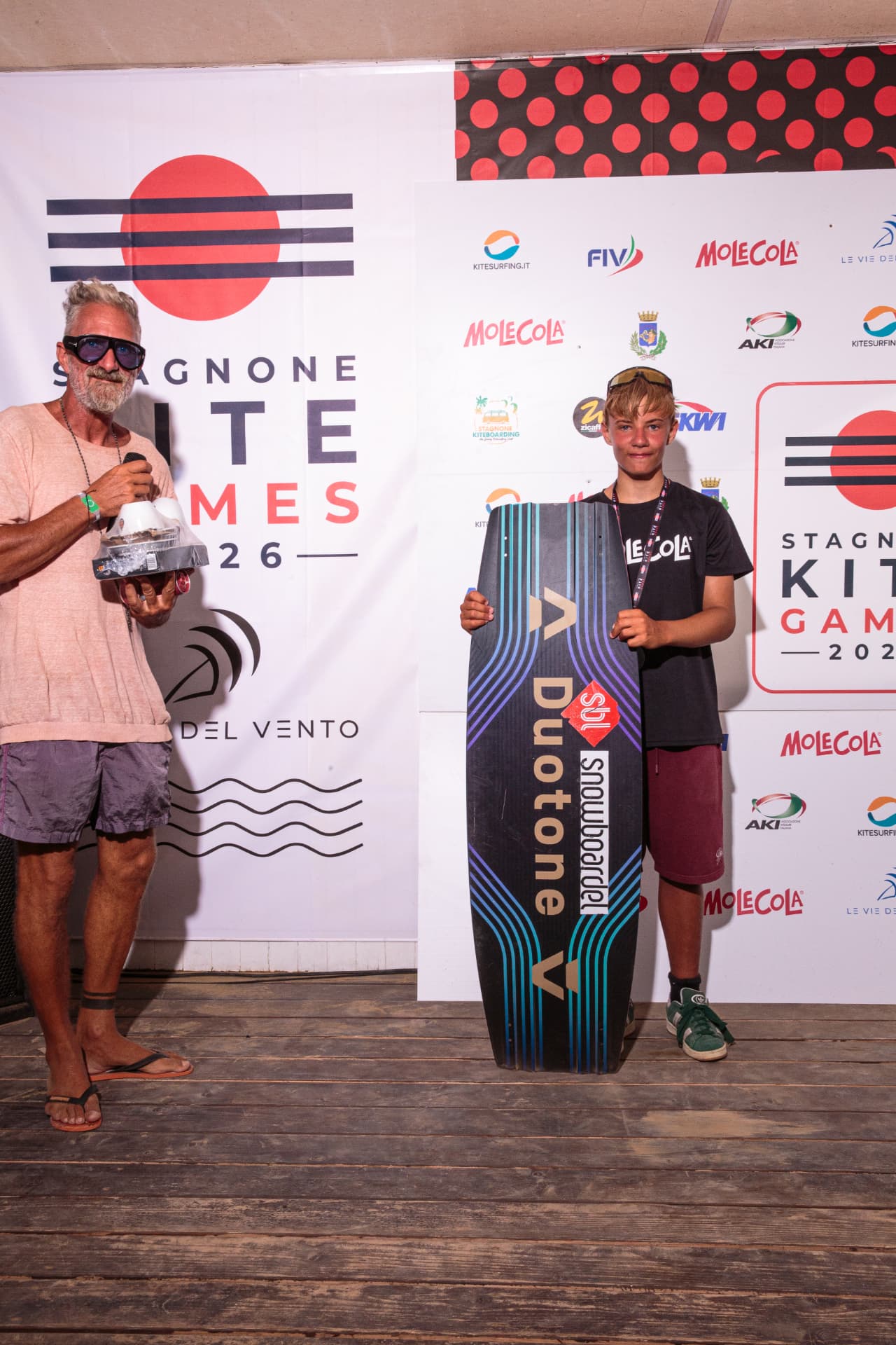Giovane vincitore con tavola Duotone sul palco — premiazione 2026