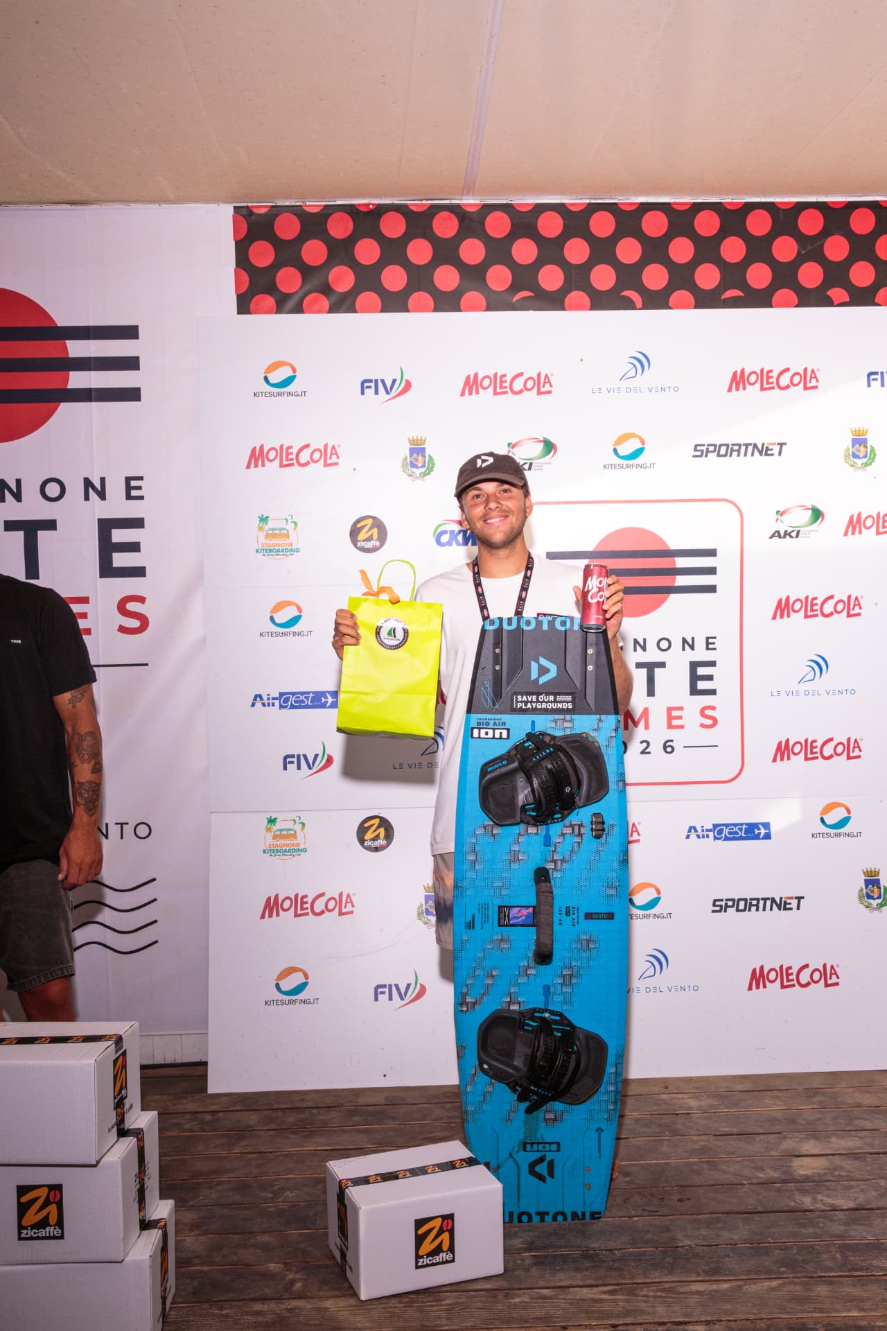 Il vincitore con tavola Duotone, zaino premio e MoleCola — premiazione 2026