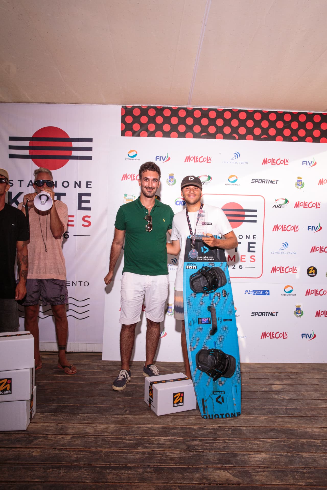 Atleta con tavola Duotone e trofeo sul palco della premiazione 2026
