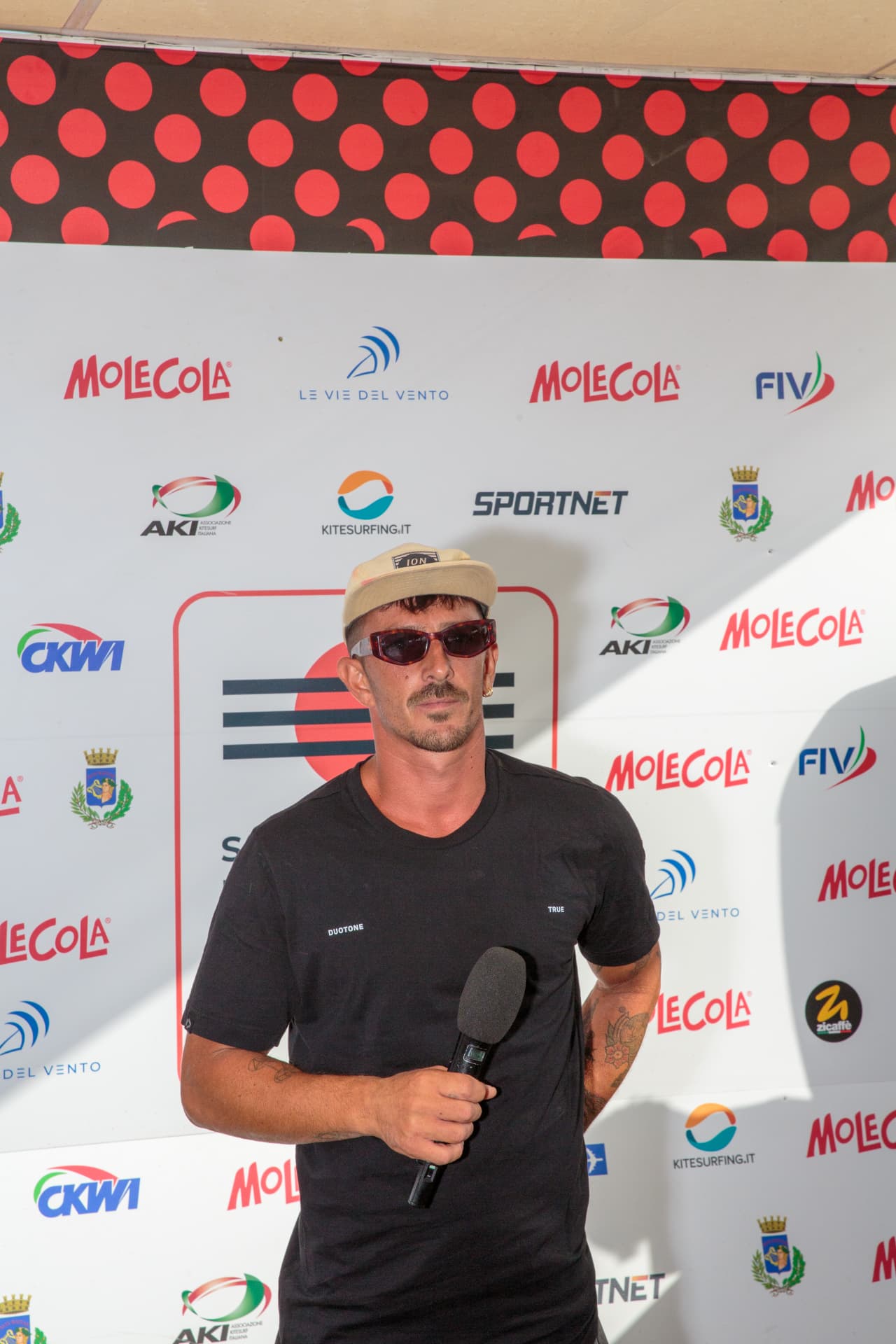 Intervista a un atleta davanti al backdrop ufficiale 2026